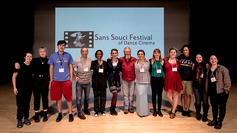 Sans Souci Festival crew, performers, and contributing artists at the 2019 Premiere, smiling at the camera with their arms around each other